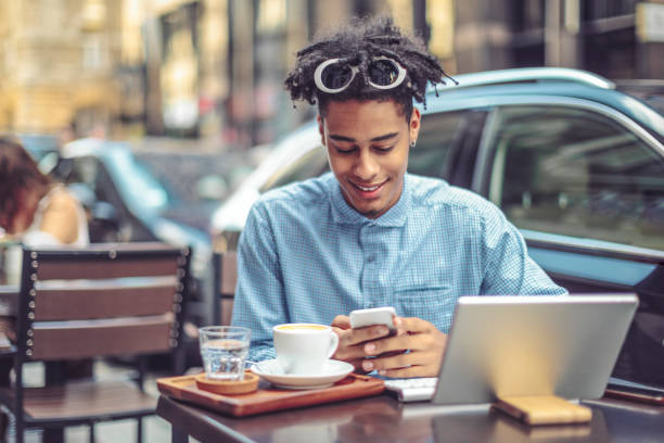istock Young man is blogging from a sidewalk caffee 1029464086