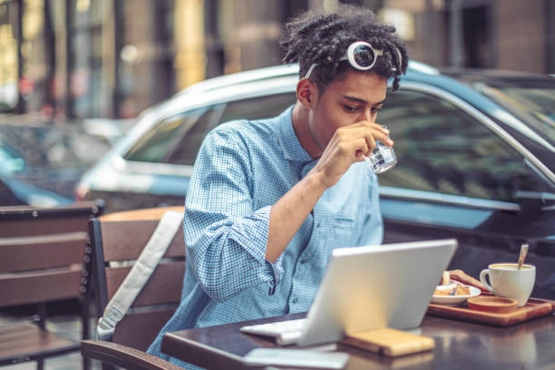 Young man is enjoying his breakfast in the city
