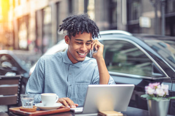 istock Young man is blogging from a sidewalk caffee 1029466782