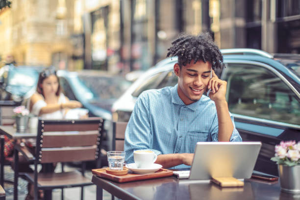istock Young man is blogging from a sidewalk caffee 1029466844