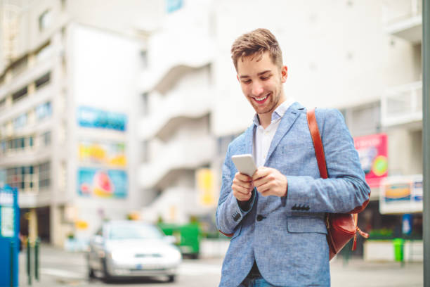 istock Young man is texting on his smartphone downtown city 1029482116