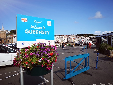 Guernsey, UK: August 25, 2018: Welcome to Guernsey tourism sign at the harbor for visitors to the island. Guernsey is one of the Channel Islands in the English Channel near the French coast and is a self-governing British Crown dependency.