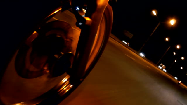 Motorcycle. A motorcycle wheel close-up on a night road.