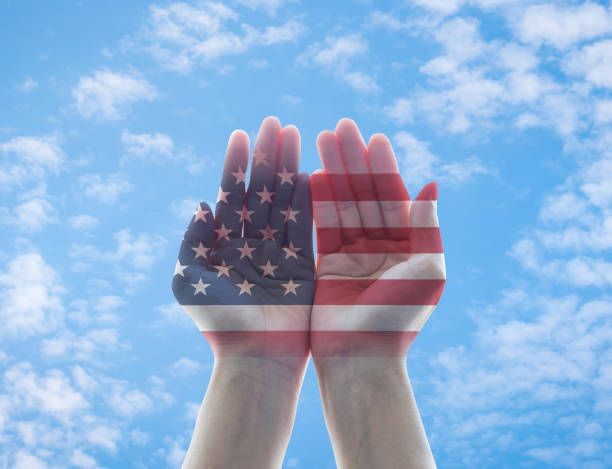 istock America flag pattern on woman's hands with open palms on blue sky background for USA public holiday remembrance concept 1029549586