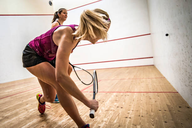 zwei junge frauen, squash spielen - racketball racket ball court stock-fotos und bilder