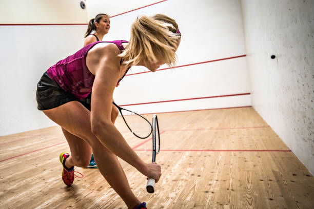 dos mujeres jóvenes jugando squash - racketball racket ball court fotografías e imágenes de stock