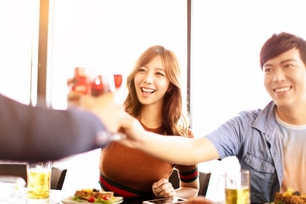 istock happy young friends drinking wine in  restaurant. 1029577670