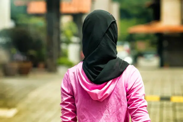 Rear shot Muslim woman wearing Hijab in residential area