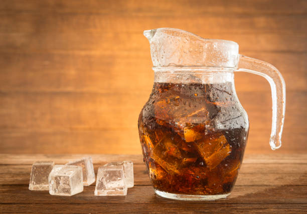 sparkling water sparkling water in a jug with ice placed on a table of dark wood. coke zero photos stock pictures, royalty-free photos & images