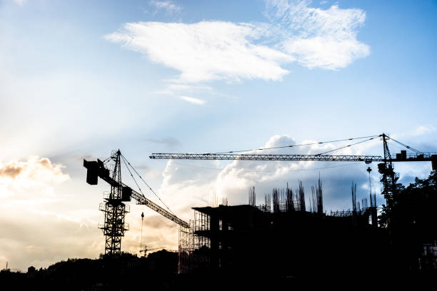 istock silhouette crane against blue sky in construction site 1029622456