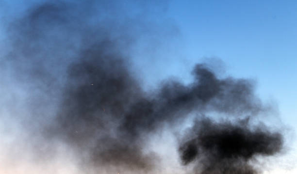 istock black smoke pillar against the blue sky background. 1029634740