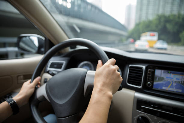 istock Hands holding steering wheel driving car on road 1029637540