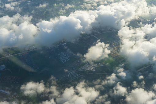 View of blue sky with cloud and city scape in plane window seen.