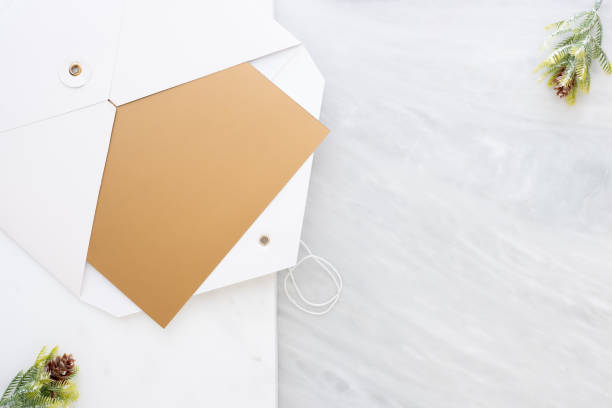 istock Top view of blank gold card in white envelop with pine leaf on two layer step of marble table top.Mock up template for display of design .luxury business items. 1029643026