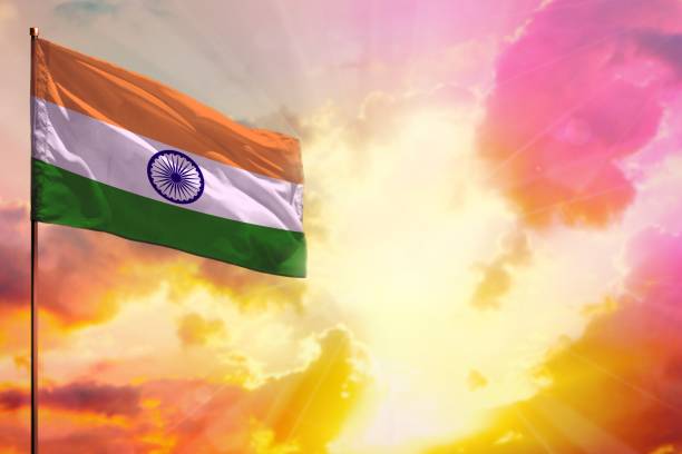 istock Fluttering India flag in top left corner mockup with the space for your text on beautiful colorful sunset or sunrise background. 1029665712