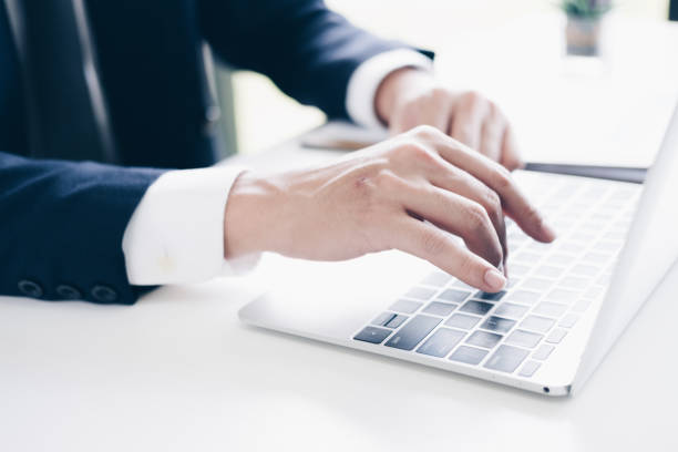 istock Businessman using laptop computer for budget planner in modern office, white background, Business and Office concept. 1029675064