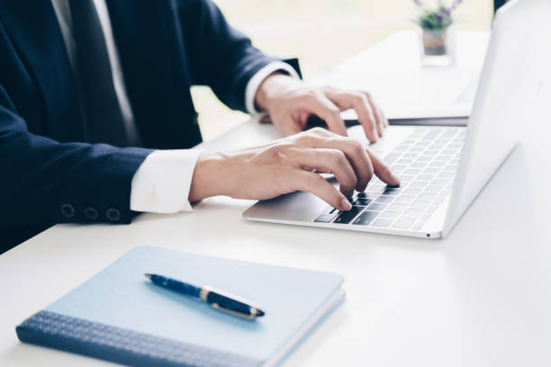 istock Businessman using laptop computer for budget planner in modern office, white background, Business and Office concept. 1029675100