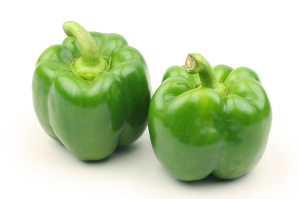istock Two green bell peppers isolated on a plain white background 1029686488