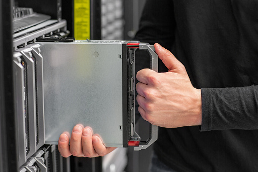 Close-up of IT technician engineer install, removes or replace blade server in a datacenter.