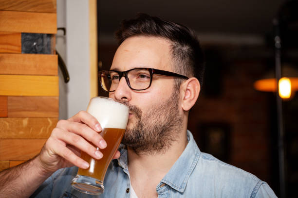 istock Guy drinking beer from glass in local pub 1029717654