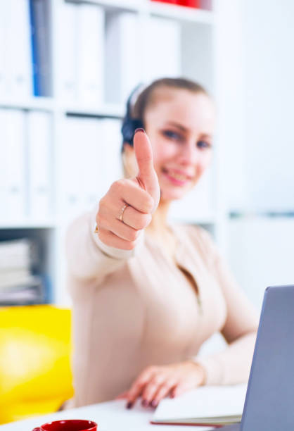 istock Cheerful smiling female customer service operator showing thumbs up in office 1029723622