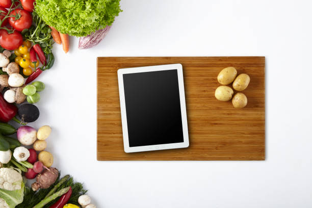 istock Digital Tablet and Potatoes on Cutting Plate with Vegetables Frame - Cut Out Screen 1029723698