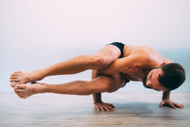 istock Young man doing yoga exercise isolated on a white background 1029727550