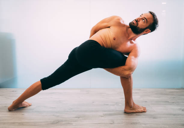 istock Young man doing yoga exercise isolated on a white background 1029727864