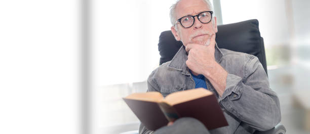 istock Portrait of mature man reading a book 1029730736