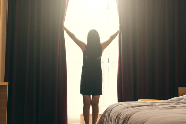 istock Woman opening curtains 1029731020