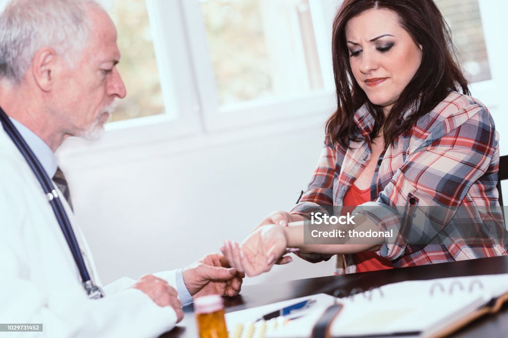 Lääkäri tutkii naispotilaan rannetta - Rojaltivapaa avainsanalla Rannekanavaoireyhtymä ja tyyppiä Kuvapankin valokuva Lääkäri tutkii naispotilaan rannetta - Rojaltivapaa avainsanalla Rannekanavaoireyhtymä ja tyyppiä Kuvapankin valokuva