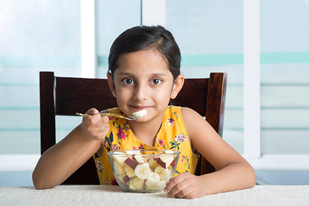 Everything good for a growing child - Stock image Child, Eating, Breakfast, Food, Girls healthy indian food stock pictures, royalty-free photos & images