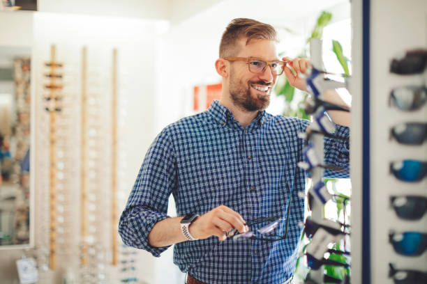 Young man buying sunglasses at the optical store