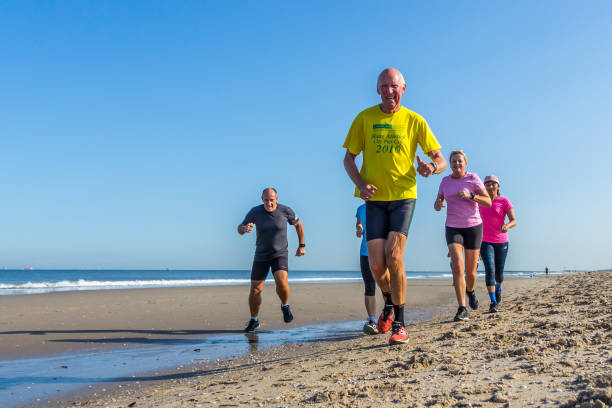 The Hague, the Netherlands - September 1 2018: men and women training on the beach in the morning. seniors running on beach
