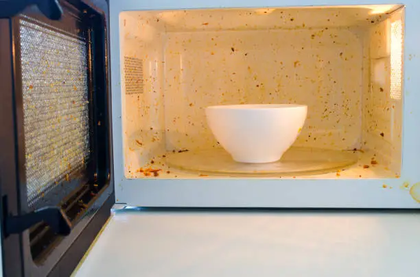 Photo of Open microwave. Dirt from food inside. Close up