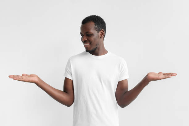 istock Young african american male choosing between two different options, holding 2 hands, isolated on gray background 1029750724
