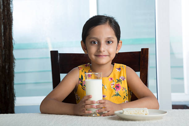 little girl drinking glass of milk - stock image - milk child drinking little girls imagens e fotografias de stock