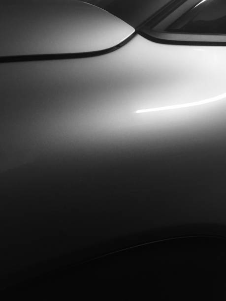 image abstraite du côté de la voiture moderne avec des surfaces lisses et brillantes en noir et blanc - silver textured gray macro photos et images de collection