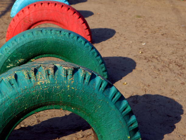 Old colored tires buried in the playground. Painted old car tires