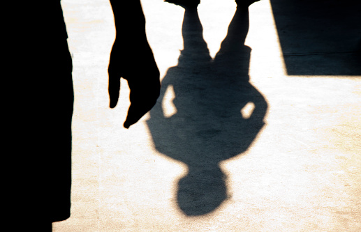 Blurry shadow silhouette of two boys confronting each other in school yard