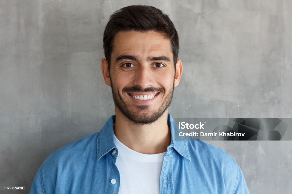 Close up portrait of young happy smiling friendly man Men Stock Photo