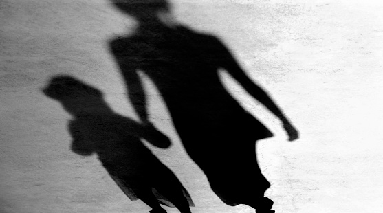 Blurry vintage shadows silhouettes of mother and daughter walking  in black and white