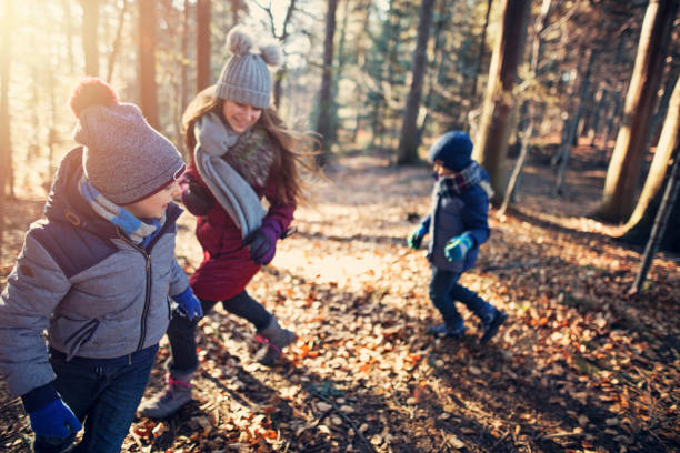 istock Happy kids playing tag in autumn forest 1029767870