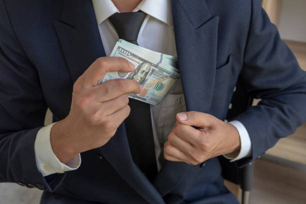 istock a man in a suit placing money in his jacket pocket 1029768572