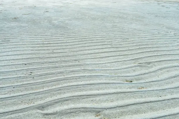 View across ripples of sand in dry patches of lake bed in the Great Salt Lake outside of Salt Lake City, UT.