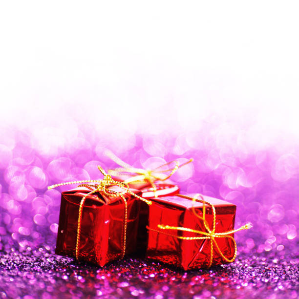 istock Decorated red holiday gifts on glitter background 1029785944