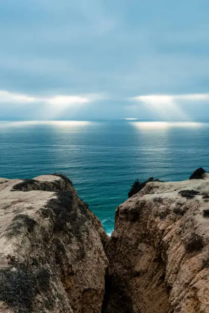 View looking out from the cliffs of Torrey Pines at rays of light over the ocean off the coast of La Jolla, CA.
