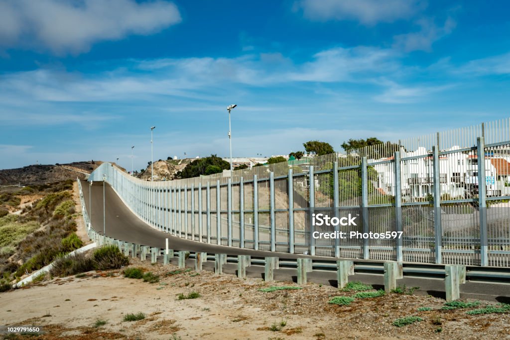 US-Mexico Border Fence in California View of the fence along the US-Mexico border from the California side looking into Tijuana, Mexico. Geographical Border Stock Photo