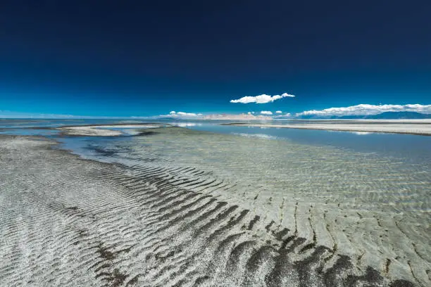 View of sand and water across the Great Salt Lake on a clear day in Utah.