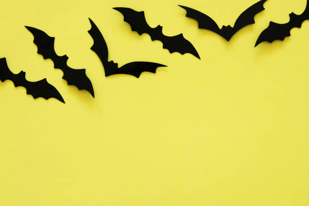 istock Halloween holiday concept. Black bats over yellow background. Top view, flat lay. 1029794482